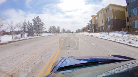 Foto de Tormenta post-invierno, la unidad en una carretera suburbana proporciona un viaje tranquilo. La pintoresca escena, con nieve adornando el paisaje, se suma a la tranquilidad de la experiencia. - Imagen libre de derechos