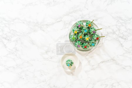 Photo for Flat lay. Cactus-shaped cake pops, beautifully decorated with luster dust, sugar flowers, and white sprinkles, arranged in celebration of Cinco de Mayo. - Royalty Free Image