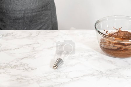 Photo for The chocolate icing is carefully transferred into a piping bag, ready to adorn the scrumptious cupcakes. - Royalty Free Image