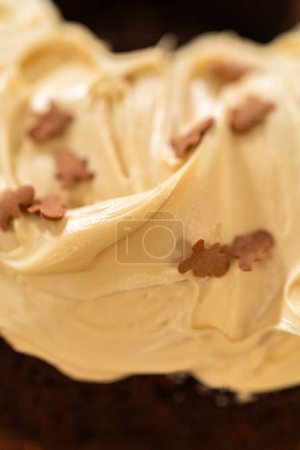 Foto de Un pastel de pan de jengibre que se escarcha generosamente con glaseado de caramelo salado y rematado con deliciosos chispas de pan de jengibre. - Imagen libre de derechos