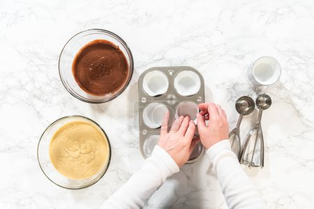 Photo for Flat lay. Cupcake foil liners are being meticulously filled with both chocolate and vanilla batter, setting the stage for the baking of deliciously diverse birthday cupcakes. - Royalty Free Image
