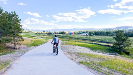 Photo for Castle Rock, Colorado, USA-June 18, 2023-A man enjoys a bike ride along a scenic trail situated in the open space of a suburban neighborhood in Colorado, immersing himself in the natural beauty - Royalty Free Image