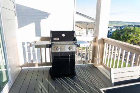 Photo for Denver, Colorado, USA-June 3, 2023-Webers sleek, closed two-burner grill, thoughtfully placed on the balcony of a suburban house, ready for a delightful outdoor cooking experience. - Royalty Free Image