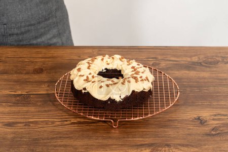 Téléchargez les photos : Un gâteau de bundt de pain d'épice généreusement givré avec glaçage au caramel salé et surmonté de délicieuses saupoudrées de pain d'épice. - en image libre de droit