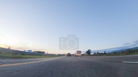 Photo for Los Angeles, California, USA-December 4, 2022-POV-As the sun sets, driving on HWY 101 near Pismo Beach, California becomes a captivating experience with the sky painted in shades of orange and pink - Royalty Free Image