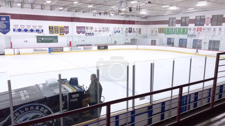 Téléchargez les photos : Denver, Colorado, États-Unis-17 février 2024 - Une patinoire se déplace sur la surface d'une patinoire de hockey vide, entourée de bannières et de sièges, préparant la glace pour les athlètes et les patineurs. - en image libre de droit