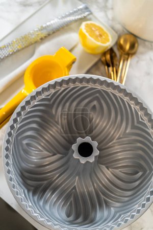 Photo for Carefully apply vegetable shortening to the bundt cake pan, ensuring a smooth, non-stick baking experience. - Royalty Free Image