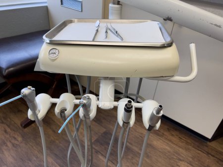 Photo for Denver, Colorado, USA-February 17, 2024- Essential tools of a dental workstation, featuring a traditional spit sink and an array of handpieces. The setup is indicative of a professional dental - Royalty Free Image