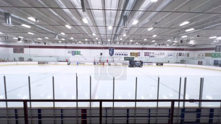 Foto de Denver, Colorado, USA-17 de febrero de 2024-resurfacer de hielo se mueve a través de la superficie de una pista de hockey vacía, rodeada de pancartas y asientos, preparando el hielo para los atletas y patinadores. - Imagen libre de derechos