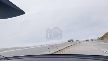 Photo for Driving along Highway 101 near Rincon Beach, California, amidst a gloomy, cloudy winter day. - Royalty Free Image