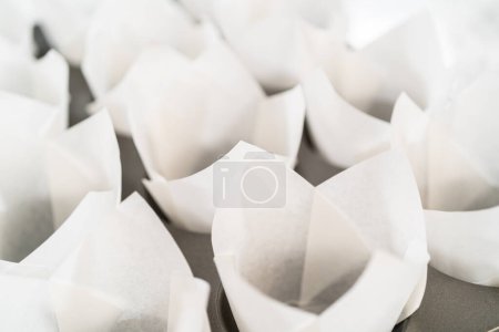 Futter Backen Cupcake-Form mit Papier Tulpeneinlagen, um No-Hefe-Zimtröllchen Cupcakes backen.
