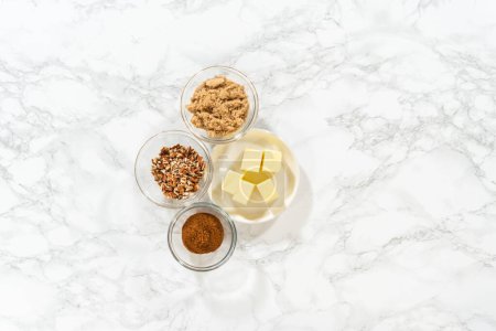 Photo for Flat lay. Measured ingredients in glass mixing bowls to bake no-yeast cinnamon roll cupcakes. - Royalty Free Image