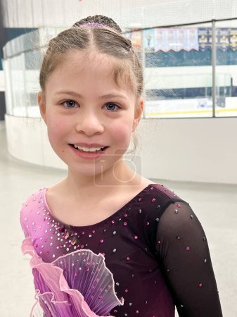Photo for Poised at the entrance to the ice, this young athlete exudes excitement and readiness, clad in a sparkling competition dress, awaiting her moment to shine - Royalty Free Image