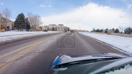 Téléchargez les photos : Naviguer sur une route de façade après la tempête hivernale offre une promenade sereine. Le paysage environnant, recouvert de neige, contribue à l'environnement paisible et pittoresque, améliorant la conduite - en image libre de droit