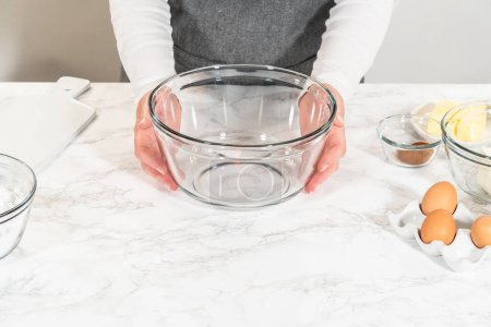 Téléchargez les photos : Dans un grand bol en verre, les ingrédients sont savamment mélangés pour créer la pâte pour la cuisson du délicieux gâteau Bundt aux carottes. - en image libre de droit