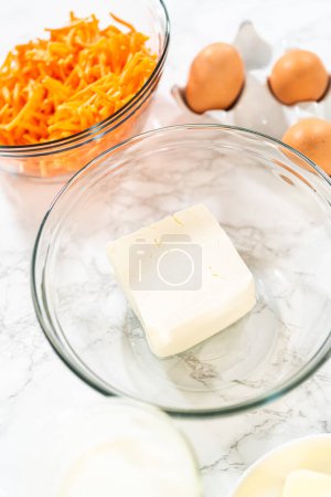 Téléchargez les photos : Les ingrédients mesurés sont placés dans des bols de mélange sur le comptoir, se préparant à cuire un délicieux gâteau Bundt aux carottes à partir d'un mélange de gâteaux. - en image libre de droit