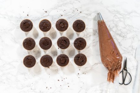 Téléchargez les photos : Pose plate. Chaque cupcake au chocolat reçoit une généreuse garniture de caramel succulent, ajoutant une couche supplémentaire de saveur et d'indulgence. - en image libre de droit