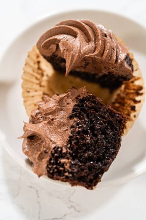 Téléchargez les photos : Un délicieux cupcake au chocolat, coupé en deux, élégamment présenté sur une assiette. - en image libre de droit