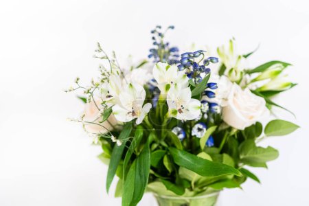 Foto de Un impresionante ramo con rosas blancas frescas y flores surtidas elegantemente dispuestas en un jarrón, exudando belleza atemporal. - Imagen libre de derechos