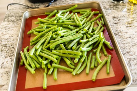 Photo for Watch as fresh green beans are beautifully roasted to perfection on a baking sheet with a silicone mat, adding a burst of flavor to your meal. - Royalty Free Image