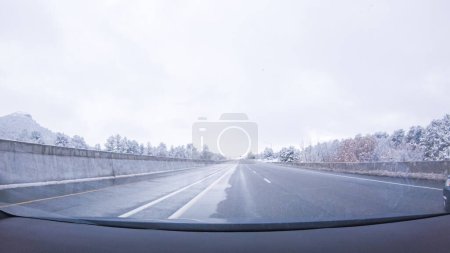 Photo for The open highway invites a peaceful drive, with snow-clad pines lining I-25 as the journey continues from Denver towards Colorado Springs on a snowy day. - Royalty Free Image