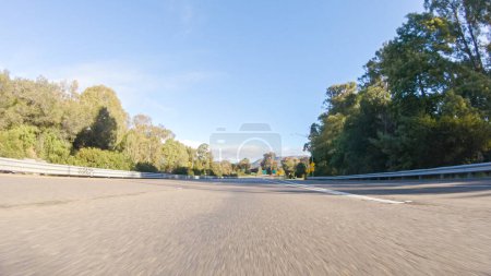 Téléchargez les photos : Par une belle journée d'hiver, une voiture parcourt l'emblématique Highway 1 près de San Luis Obispo, en Californie. Le paysage environnant est brunâtre et tamisé, avec des collines ondulantes et des zones côtières - en image libre de droit