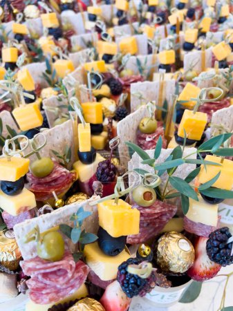 Photo for Denver, Colorado, USA-March 3, 2024-This vibrant display features an assortment of cheese and charcuterie bites, elegantly presented with fresh berries and herbs for a delightful appetizer selection - Royalty Free Image