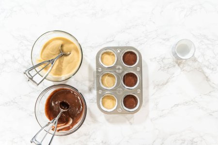 Photo for Flat lay. Cupcake foil liners are being meticulously filled with both chocolate and vanilla batter, setting the stage for the baking of deliciously diverse birthday cupcakes. - Royalty Free Image