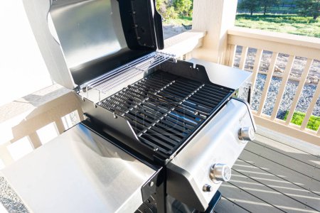 Photo for Denver, Colorado, USA-June 3, 2023-Webers sleek two-burner grill, its lid invitingly open, is thoughtfully positioned on the balcony of a suburban house, poised for an exceptional outdoor cooking - Royalty Free Image