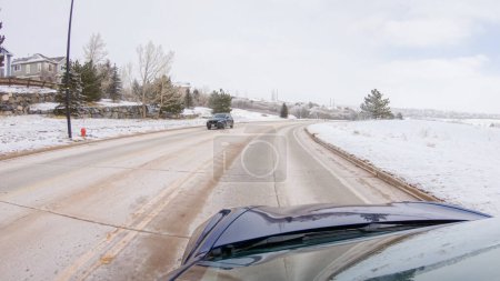 Foto de Castle Pines, Colorado, EE. UU., 30 de enero de 2023-Recorriendo una carretera suburbana recién despejada después de una tormenta de invierno, uno experimenta un viaje sereno a través de un exclusivo vecindario residencial. Cubierto de nieve - Imagen libre de derechos