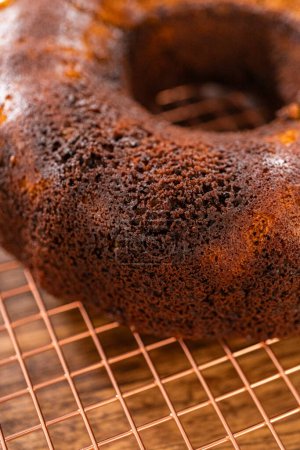 Téléchargez les photos : Le gâteau de bundt de pain d'épice se refroidit gracieusement sur un support métallique, attendant son glaçage au caramel doux. - en image libre de droit