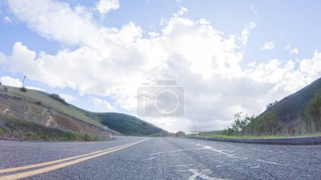 Photo for Vehicle is cruising along the Cuyama Highway under the bright sun. The surrounding landscape is illuminated by the radiant sunshine, creating a picturesque and inviting scene as the car travels - Royalty Free Image