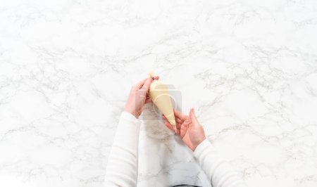 Foto de Acostado. Rellenar bolsas de tuberías con glaseado de queso crema para cupcakes de canela sin levadura. - Imagen libre de derechos