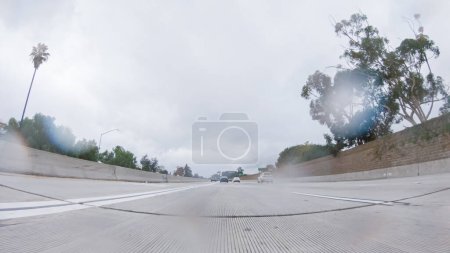 Téléchargez les photos : Au milieu d'une journée pluvieuse d'hiver, conduite sur la route 134 près de Los Angeles, Californie, capture l'atmosphère à travers des lentilles recouvertes de gouttes de pluie, ajoutant une perspective unique et lunatique au voyage. - en image libre de droit
