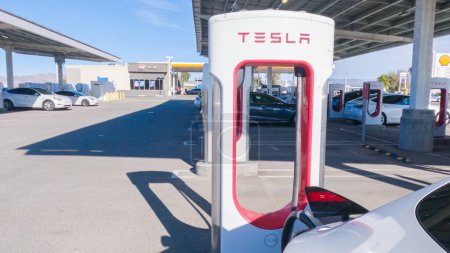 Téléchargez les photos : Baker, Californie, États-Unis-3 décembre 2022-Pendant la journée, on voit un véhicule Tesla se recharger à une station de supercharge Tesla, en utilisant l'infrastructure de recharge à grande vitesse pour une recharge pratique et efficace - en image libre de droit