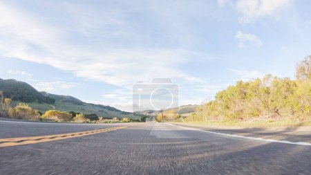 Téléchargez les photos : Se prélasser dans la beauté d'une journée ensoleillée d'hiver, conduire sur l'autoroute 1 près de Las Cruces, Californie offre une vue imprenable sur le paysage côtier pittoresque dans un contexte de ciel bleu clair. - en image libre de droit