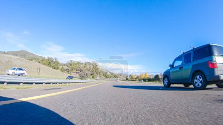 Téléchargez les photos : Santa Maria, Californie, États-Unis-6 décembre 2022-Par une belle journée d'hiver, une voiture parcourt l'emblématique Highway 1 près de San Luis Obispo, en Californie. Le paysage environnant est brunâtre et tamisé, avec - en image libre de droit