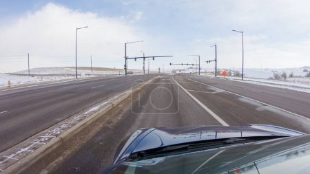 Photo for Navigating a frontage road post-winter storm offers a serene drive. The surrounding landscape, blanketed in snow, contributes to the peaceful and picturesque environment, enhancing the driving - Royalty Free Image