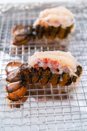 Téléchargez les photos : Queues de homard crues sur une plaque de cuisson avec papier d'aluminium de cuisine, prêtes à être cuites au four. - en image libre de droit
