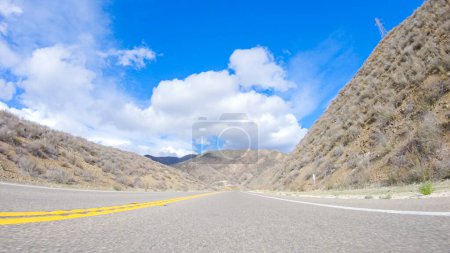 Téléchargez les photos : Le véhicule roule le long de la Cuyama Highway sous le soleil. Le paysage environnant est illuminé par le soleil radieux, créant une scène pittoresque et accueillante pendant que la voiture se déplace - en image libre de droit