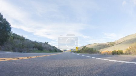 Die Fahrt auf dem HWY 1 in der Nähe von Las Cruces, Kalifornien, in der Schönheit eines sonnigen Wintertages bietet einen atemberaubenden Blick auf die malerische Küstenlandschaft vor dem Hintergrund eines klaren blauen Himmels.