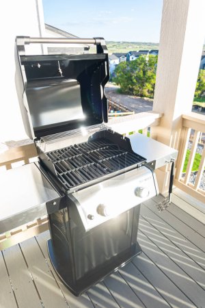 Photo for Denver, Colorado, USA-June 3, 2023-Webers sleek two-burner grill, its lid invitingly open, is thoughtfully positioned on the balcony of a suburban house, poised for an exceptional outdoor cooking - Royalty Free Image