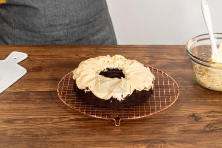 Téléchargez les photos : Un gâteau de bundt de pain d'épice généreusement givré avec glaçage au caramel salé et surmonté de délicieuses saupoudrées de pain d'épice. - en image libre de droit