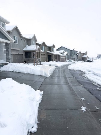 Téléchargez les photos : Castle Rock, Colorado, États-Unis-16 mars 2024-Neige recouvre une rue de banlieue, où les maisons se tiennent dans le repos tranquille et les allées révèlent le travail du matin contre les dérives incessantes de l'hiver. - en image libre de droit