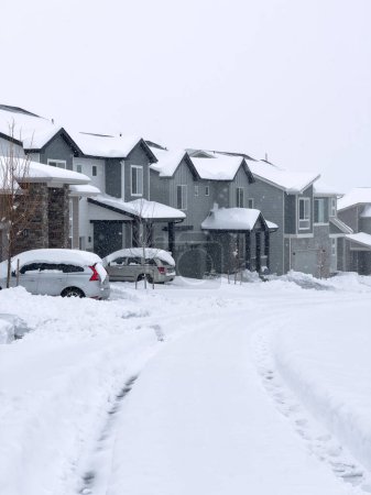 Téléchargez les photos : Castle Rock, Colorado, États-Unis-16 mars 2024-La scène représente une tranquillité suburbaine avec des maisons bordant une rue recouverte de neige, ponctuées d'un sentier dégagé qui traverse le pays des merveilles hivernales - en image libre de droit