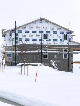 Foto de Castle Rock, Colorado, Estados Unidos-16 de marzo de 2024-La nieve fresca cubre suavemente un nuevo vecindario suburbano en construcción, donde las estructuras emergentes esperan su finalización, ubicado en un entorno invernal. - Imagen libre de derechos