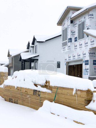 Foto de Castle Rock, Colorado, Estados Unidos-16 de marzo de 2024-La nieve fresca cubre suavemente un nuevo vecindario suburbano en construcción, donde las estructuras emergentes esperan su finalización, ubicado en un entorno invernal. - Imagen libre de derechos