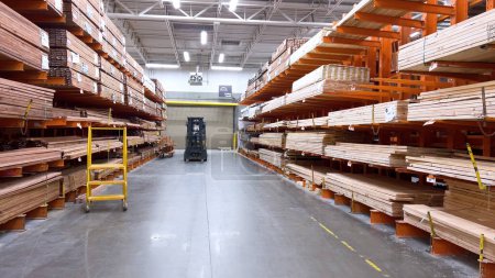 Photo for Castle Rock, Colorado, USA-March 21, 2024- A bright, orderly aisle of a home improvement store, with a forklift actively restocking supplies, underscores the efficiency and vast selection of building - Royalty Free Image