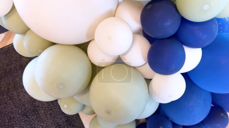 Foto de Un ingenioso arreglo de globos en diferentes tonos de azul y blanco crea un caprichoso telón de fondo, ideal para celebraciones o eventos. - Imagen libre de derechos