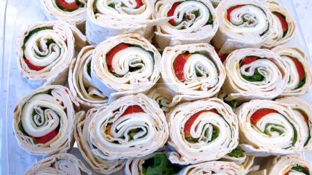 Eine köstliche Auswahl an Windrad-Sandwiches gefüllt mit frischem Gemüse und Wurstwaren, perfekt für jede Zusammenkunft oder schnelles Mittagessen.